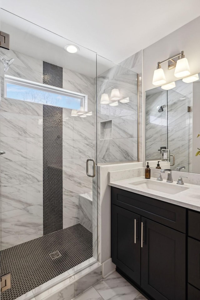 bathroom featuring marble finish floor, vanity, and a marble finish shower