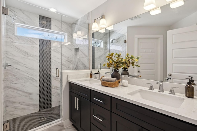 full bathroom featuring marble finish floor, a sink, and a marble finish shower