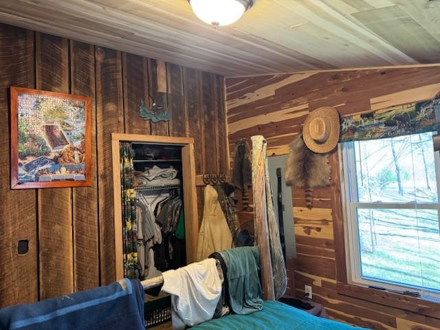 unfurnished bedroom featuring a closet, wood ceiling, and wooden walls