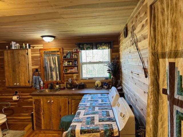 bar featuring wooden ceiling, wood walls, and a sink