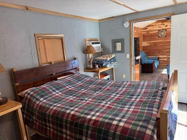 bedroom featuring a wall mounted air conditioner and wood finished floors