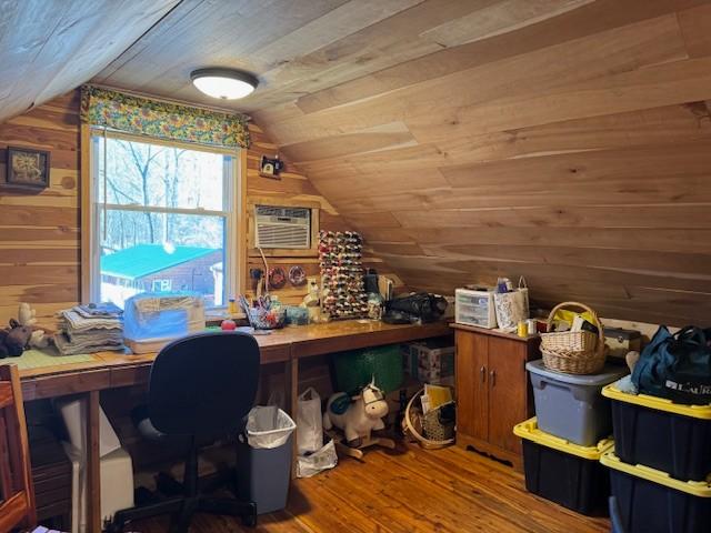 office space with vaulted ceiling, wood ceiling, wood walls, and wood finished floors