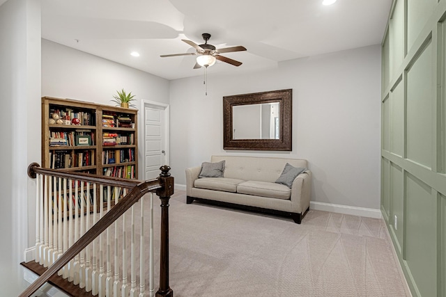 living area with baseboards, light colored carpet, ceiling fan, an upstairs landing, and recessed lighting