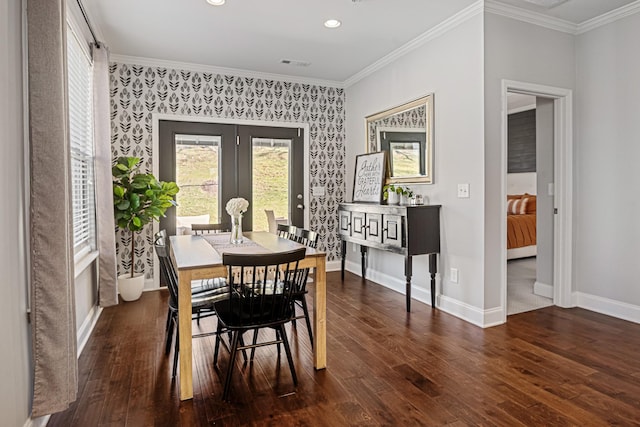 dining room featuring dark wood-style flooring, visible vents, baseboards, ornamental molding, and wallpapered walls