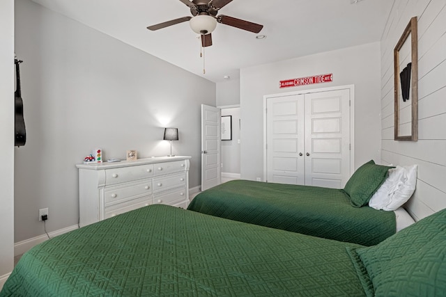 bedroom with ceiling fan, a closet, and baseboards