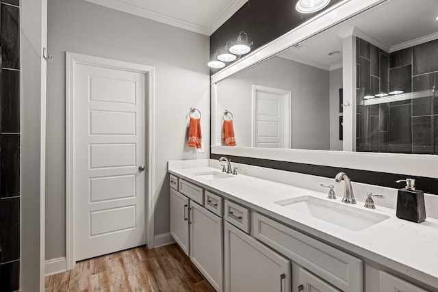 full bathroom with wood finished floors, a sink, and crown molding