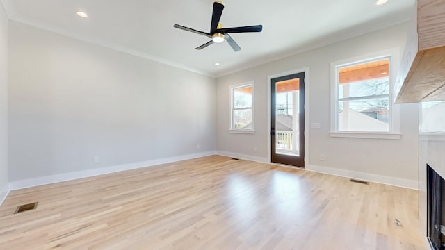 spare room featuring baseboards, a fireplace, visible vents, and crown molding