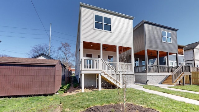 back of house with stairway, a porch, and a yard