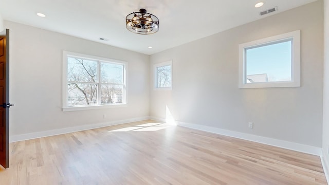 unfurnished room with recessed lighting, visible vents, light wood finished floors, and baseboards