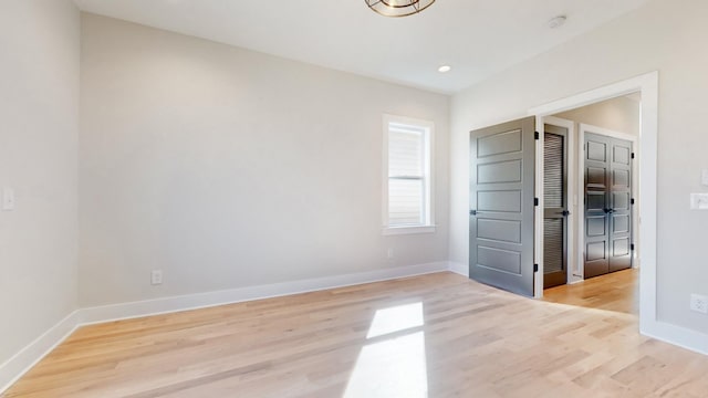 unfurnished bedroom featuring light wood-style floors, recessed lighting, and baseboards