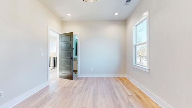 spare room featuring light wood-style floors, recessed lighting, visible vents, and baseboards