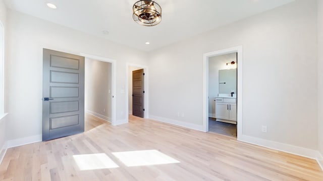 unfurnished bedroom with light wood-style flooring, baseboards, connected bathroom, and recessed lighting