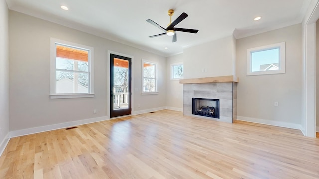 unfurnished living room featuring a tile fireplace, light wood-style flooring, and baseboards