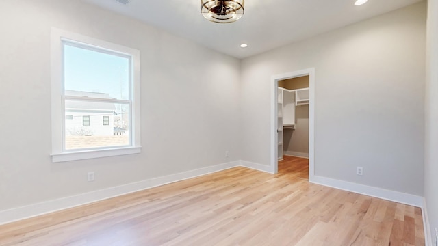 unfurnished room with light wood-type flooring, baseboards, and recessed lighting