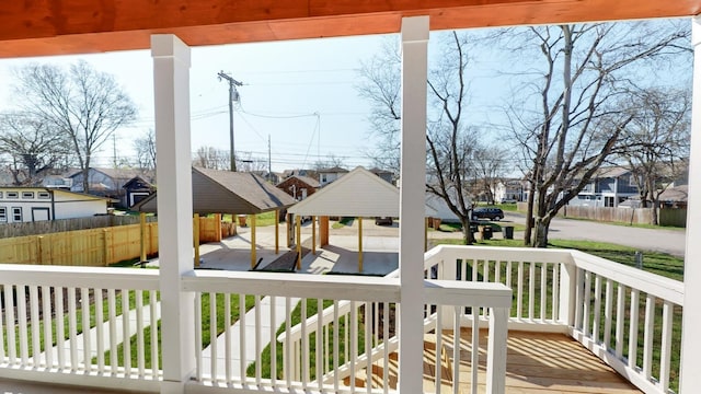 wooden terrace featuring a residential view, fence, and a gazebo