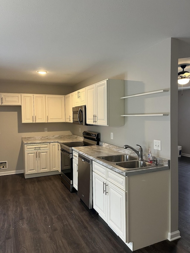 kitchen with appliances with stainless steel finishes, dark wood-type flooring, white cabinetry, open shelves, and a sink