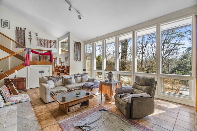 sunroom featuring vaulted ceiling, track lighting, and a healthy amount of sunlight