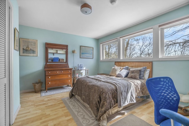 bedroom with light wood-style flooring and baseboards