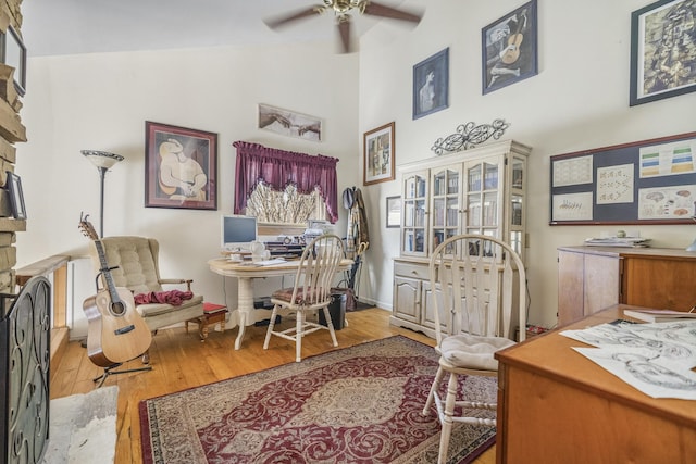 office space with high vaulted ceiling, baseboards, ceiling fan, and light wood finished floors