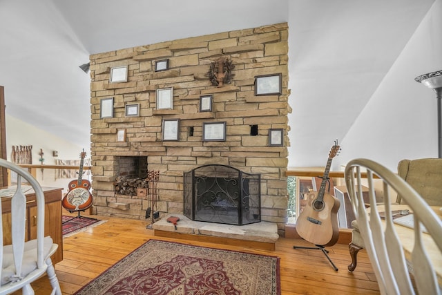 living area featuring a stone fireplace and wood finished floors