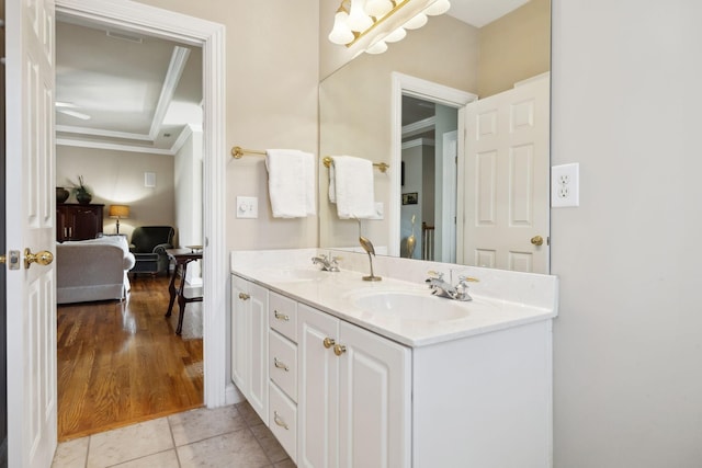 bathroom featuring double vanity, ornamental molding, a sink, and tile patterned floors