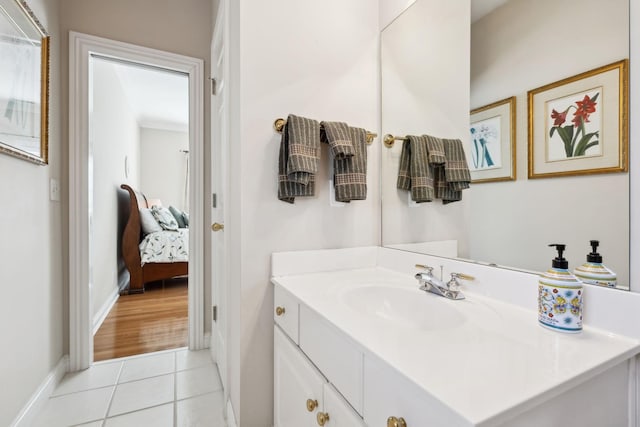 ensuite bathroom with tile patterned flooring, baseboards, connected bathroom, and vanity