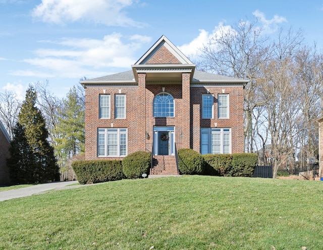 view of front of house with brick siding and a front lawn