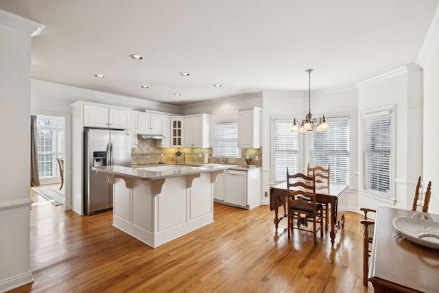 kitchen featuring dishwasher, glass insert cabinets, a center island, light countertops, and stainless steel refrigerator with ice dispenser