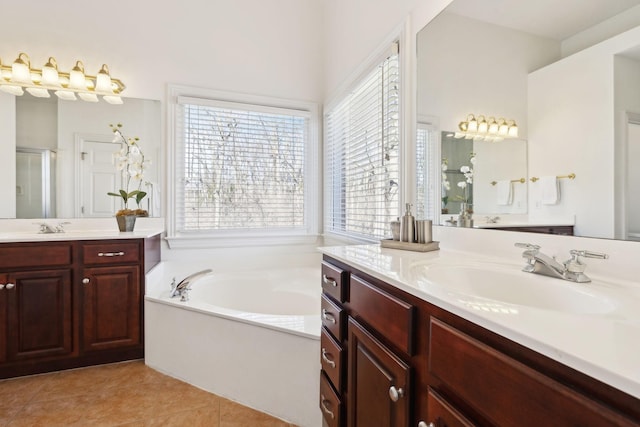 full bathroom with a stall shower, tile patterned floors, a sink, a garden tub, and two vanities