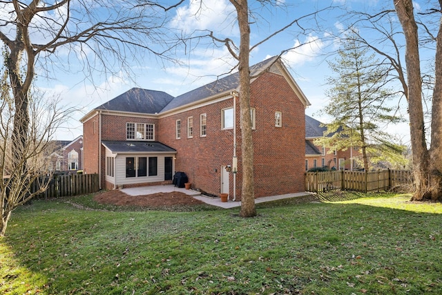 back of property featuring a yard, a fenced backyard, a patio area, and brick siding