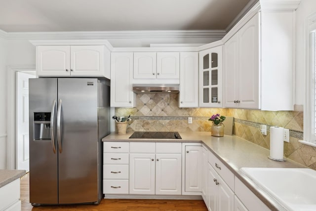 kitchen featuring under cabinet range hood, stainless steel refrigerator with ice dispenser, glass insert cabinets, and white cabinets