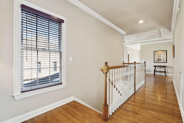 corridor featuring ornamental molding, wood finished floors, and an upstairs landing