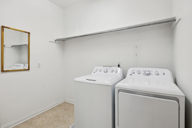 laundry area featuring laundry area, separate washer and dryer, light floors, and baseboards