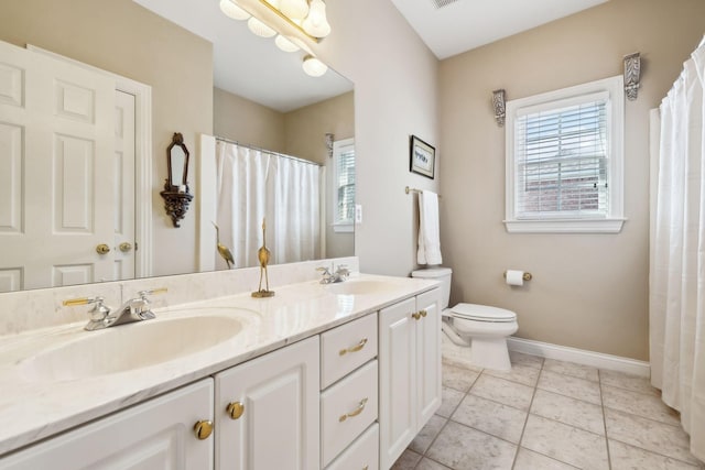 bathroom featuring tile patterned flooring, a sink, baseboards, and double vanity