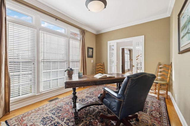 office area with ornamental molding, wood finished floors, visible vents, and baseboards