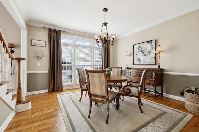 dining area featuring a chandelier, ornamental molding, stairway, and light wood-style flooring