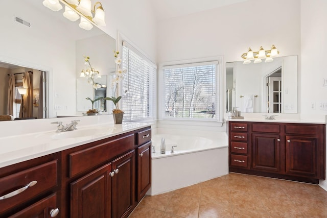 bathroom featuring tile patterned floors, visible vents, a sink, and a bath