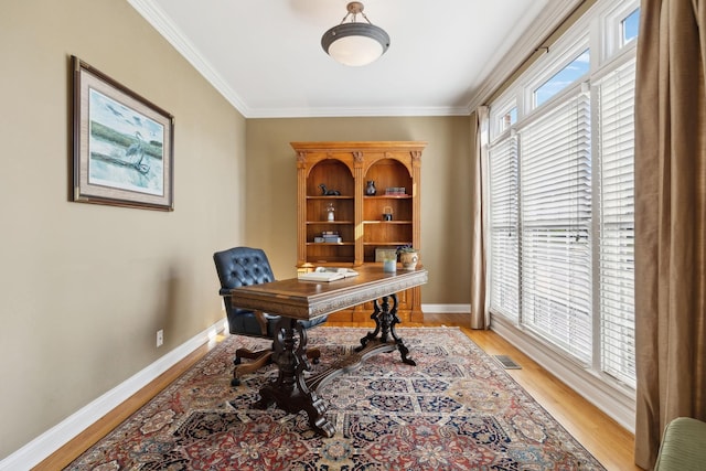 office space with ornamental molding, light wood-type flooring, and baseboards