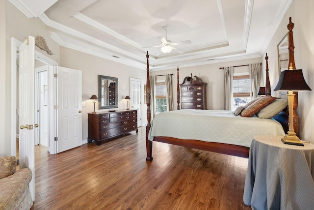 bedroom with ornamental molding, a raised ceiling, ceiling fan, and dark wood-style flooring