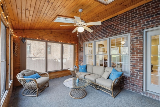 sunroom / solarium featuring lofted ceiling with skylight, wooden ceiling, and a ceiling fan