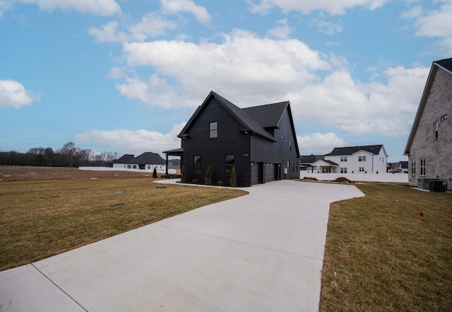 view of side of home featuring a garage, a lawn, a residential view, and central air condition unit