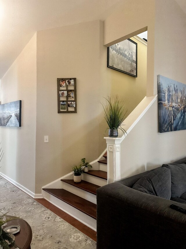 staircase with baseboards and wood finished floors