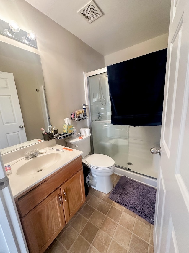 bathroom with toilet, a stall shower, visible vents, and vanity