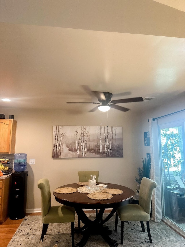 dining area with light wood-type flooring, ceiling fan, and visible vents
