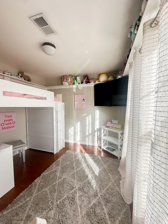 unfurnished bedroom featuring visible vents and dark wood finished floors