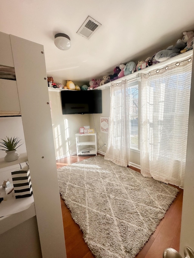 bedroom with visible vents and wood finished floors