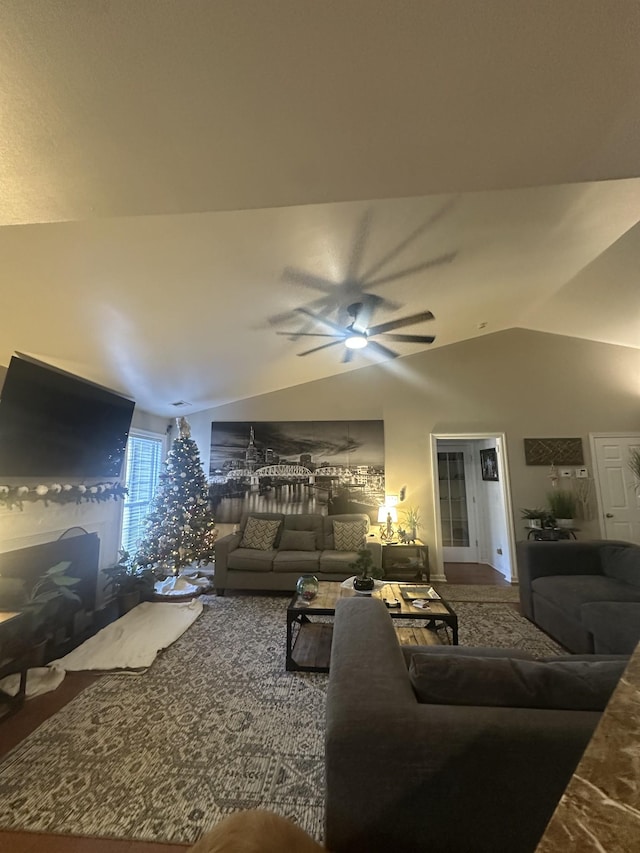 living room featuring a ceiling fan and vaulted ceiling