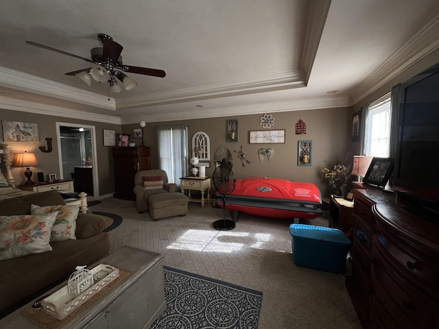 living room featuring ornamental molding, a raised ceiling, and a ceiling fan