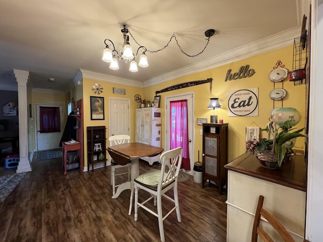 dining room featuring ornamental molding, dark wood-style flooring, an inviting chandelier, and ornate columns