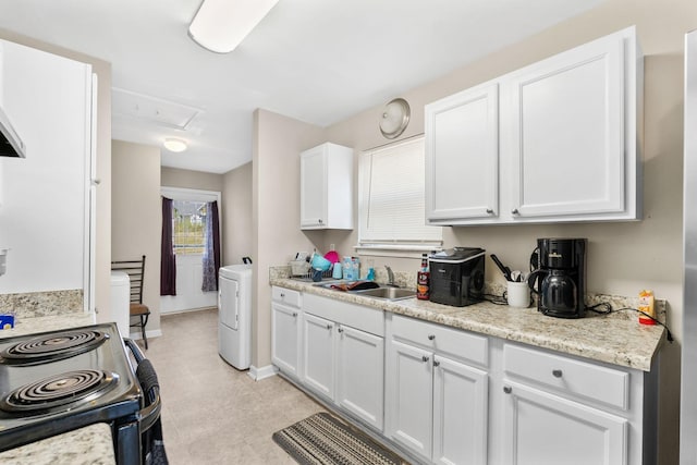 kitchen featuring white cabinets, light stone counters, washer / clothes dryer, a sink, and range with electric stovetop